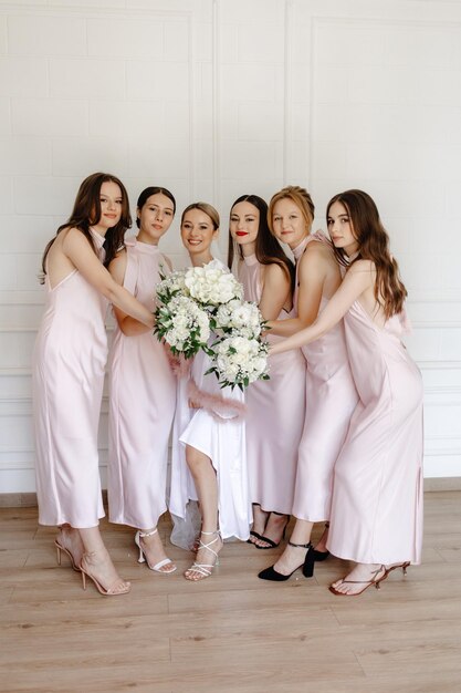 eine Braut und ihre Brautjungfern posieren für ein Foto mit Blumen