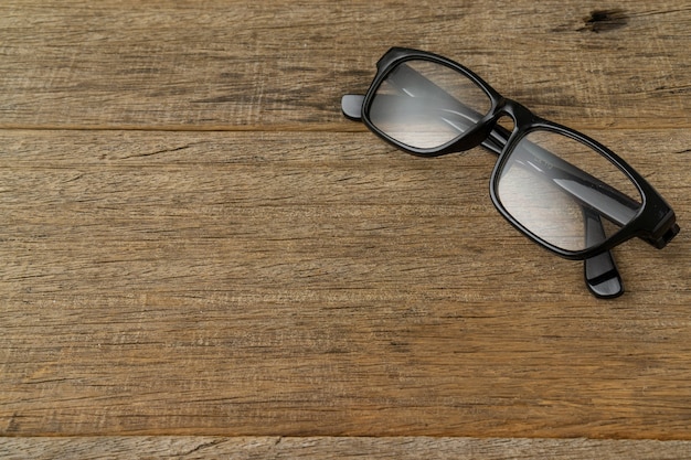 Eine Brille auf schäbigem Holzbrett.