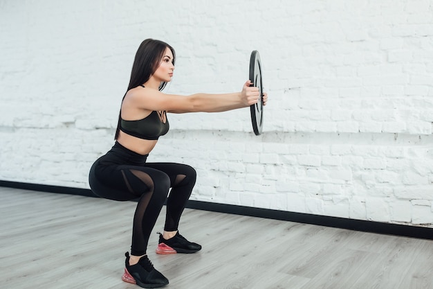 Eine, brünette kaukasische Frau, die Fitness-Bodybuilding-Übungen im Studio ausübt. Speicherplatz kopieren.