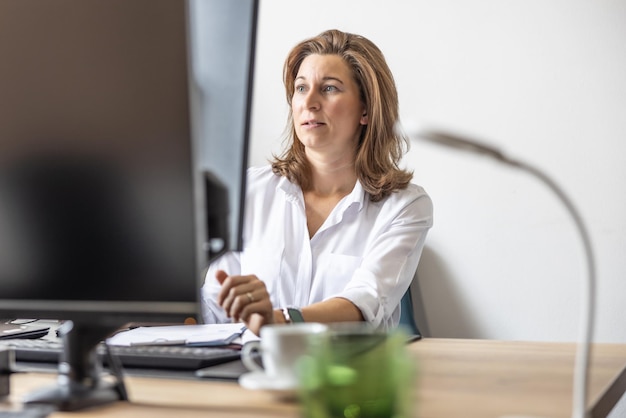 Eine Buchhalterin oder Geschäftsfrau arbeitet in ihrem Büro an einem Computer