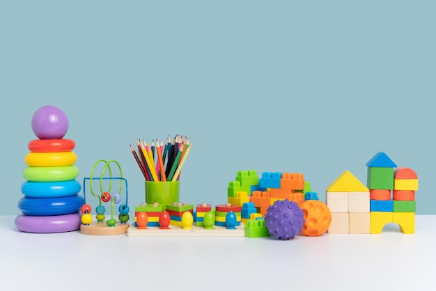 Eine bunte Reihe von Lernspielzeug für Kinder im Vorschulalter Holz- und Kunststoffspielzeug auf blauem Hintergrund Kopierbereich