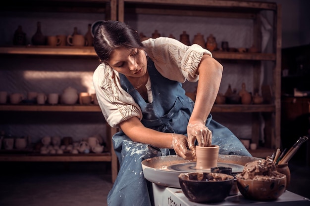 Eine charmante Meisterin demonstriert den Prozess der Herstellung von Keramikgeschirr mit der alten Technologie. Handwerkliche Herstellung.