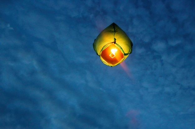 Eine chinesische Laterne fliegt hoch in den Nachthimmel Wünsche beim Loslassen einer fliegenden Papierlaterne in den Himmel