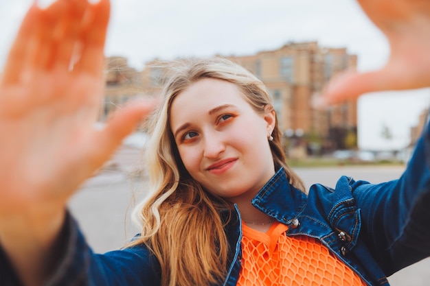 Eine coole Teenagerin macht ein Selfie auf der Straße Eine wunderschöne Blondine fotografiert sich selbst beim Spaziergang durch die Stadt Generation z