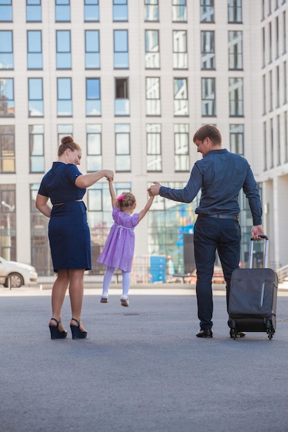 Eine dreiköpfige Familie auf einem Spaziergang Glückliches springendes Kind