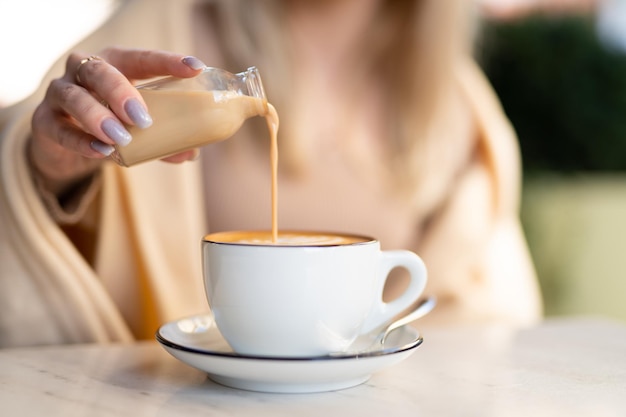 Eine duftende und warme Tasse Cappuccino mit einem ziehenden Herz für Sahne