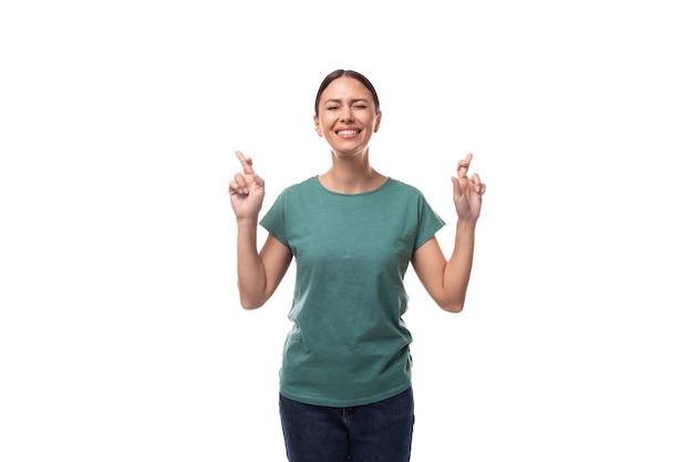 Eine einjährige, schlanke, brünette Frau mit gerafften Haaren, gekleidet in ein grünes Basic-T-Shirt, kreuzte sie