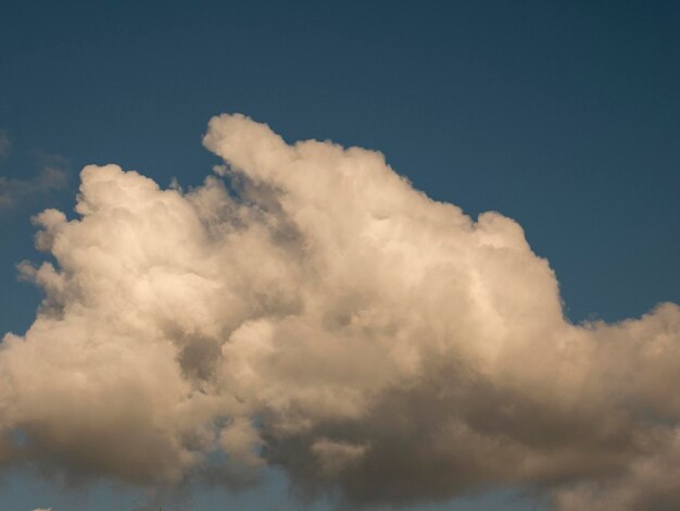 Eine einzelne flauschige Wolke über dem Hintergrund des Sonnenuntergangs