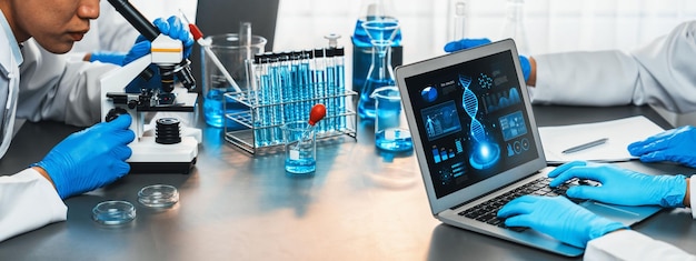 Eine engagierte Wissenschaftlergruppe arbeitet an fortschrittlicher Biotechnologie-Computersoftware zum Studium oder zur Analyse von DNA-Daten, nachdem sie einen wissenschaftlichen Durchbruch durch chemische Experimente in medizinischen Laboratorien erzielt hat.