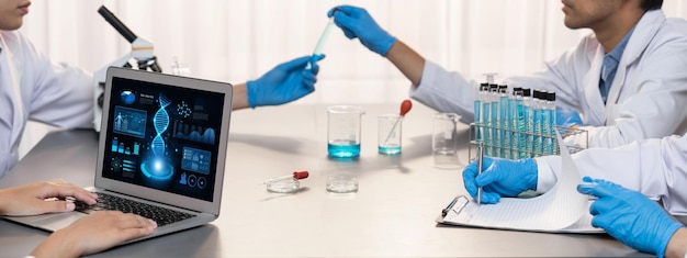 Eine engagierte Wissenschaftlergruppe arbeitet an fortschrittlicher Biotechnologie-Computersoftware zum Studium oder zur Analyse von DNA-Daten, nachdem sie einen wissenschaftlichen Durchbruch durch chemische Experimente in medizinischen Laboratorien erzielt hat.
