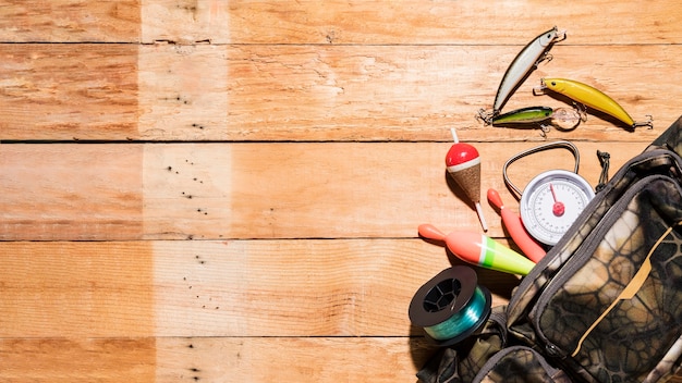 Eine erhöhte Ansicht der Fischenflöße; locken; Rolle und Maßskala von der Tasche auf hölzernem Schreibtisch