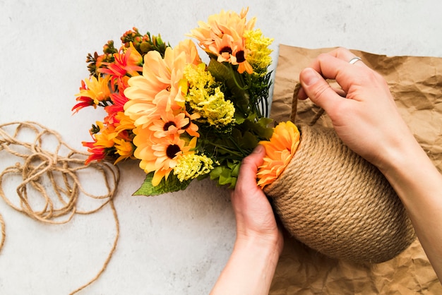 Eine erhöhte Ansicht einer Frau, die die Vase mit Schnur macht