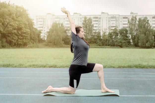 Eine erwachsene Frau macht Yoga im Freien