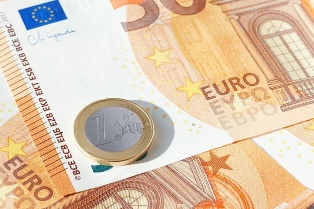 Eine EU-Euro-Münze auf einem Haufen 50-Euro-Scheine EU-Wirtschaft und Finanzen Bargeld Währungshintergrund Nahaufnahme