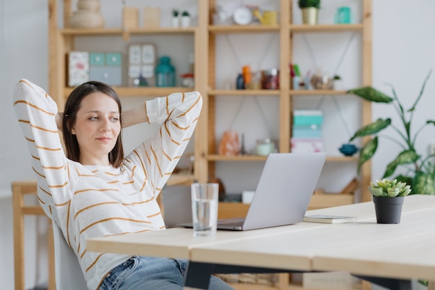 Eine europäische Frau arbeitet in ihrem Homeoffice mit einem Laptop oder schaut sich ein Webinar an