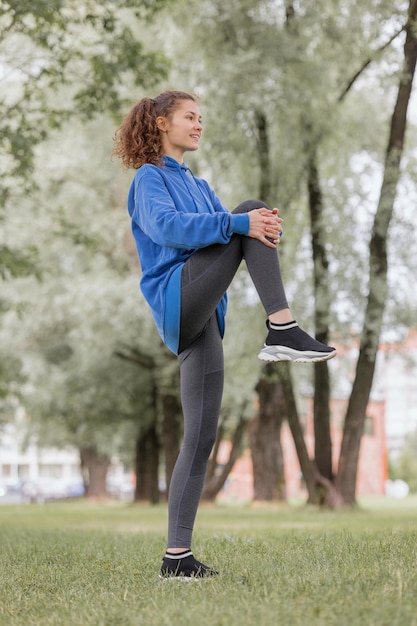 Eine europäische Frau treibt Sport in einem Park oder an einem öffentlichen Ort, um sich aufzuwärmen und an der frischen Luft zu joggen