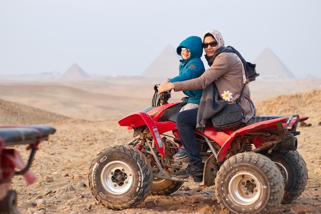 Eine Familie auf einem Quad vor den Pyramiden von Gizeh