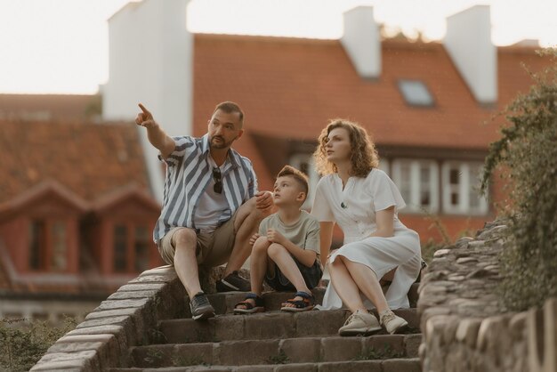 Eine Familie entspannt sich auf der Treppe zwischen den Dächern einer alten europäischen Stadt