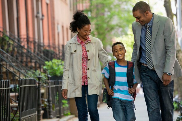 Eine Familie im Freien in der Stadt Zwei Eltern und ein kleiner Junge gehen zusammen