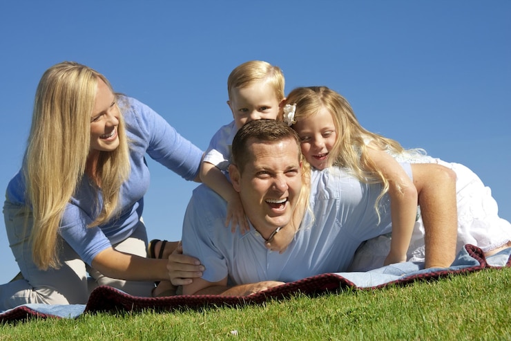 Foto eine familie liegt mit den armen um den kopf auf dem gras