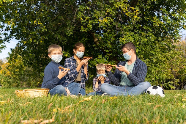 Eine Familie mit Schutzmasken im Park
