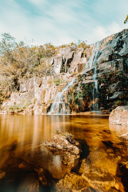 Eine farbenfrohe Langzeitbelichtung eines Wasserfalls mitten im Wald