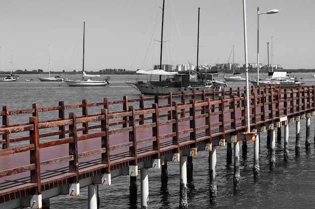 Eine Farbfotografie der Fußgängerbrücke mit Booten im Hintergrund