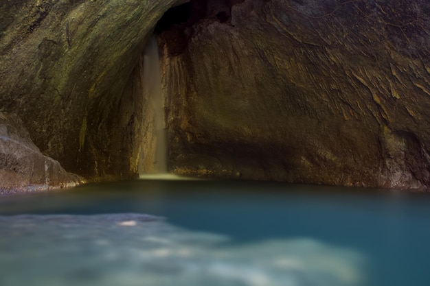 Eine Felsformation mit einem Wasserfall im Hintergrund