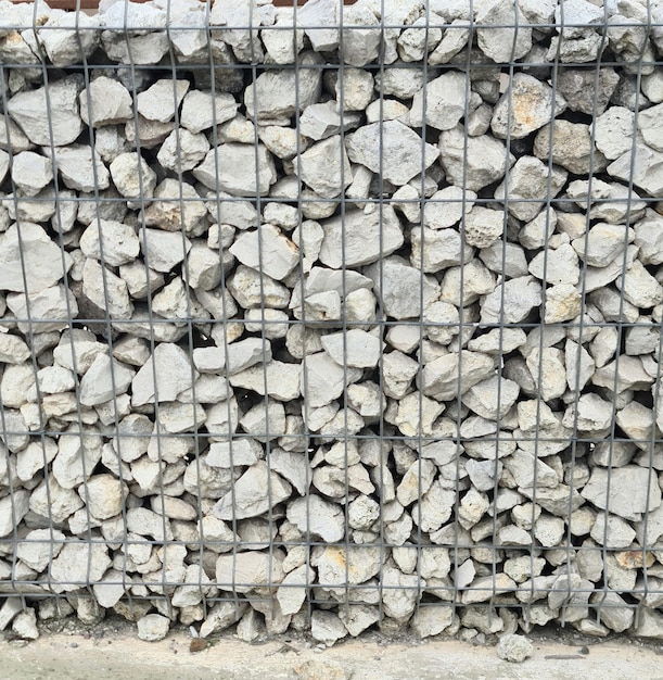 Eine Felswand mit einem Drahtgeflecht, auf dem „Rock“ steht