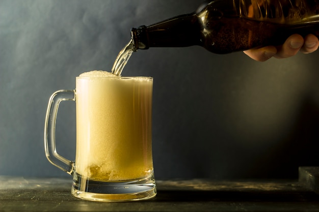 Eine Flasche Bier wird in einen Becher gegossen.