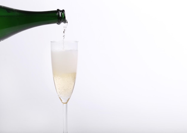 Eine Flasche Champagner ergießt sich in ein Glas.