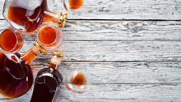 Eine Flasche Cognac und Gläser auf weißem Hintergrund aus Holz Brandy Draufsicht Freier Platz für Ihren Text