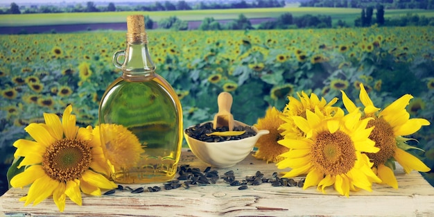 Eine Flasche Öl, frische Sonnenblumenblüten und Samen auf dem Tisch, Bio-Produkte, Ernte