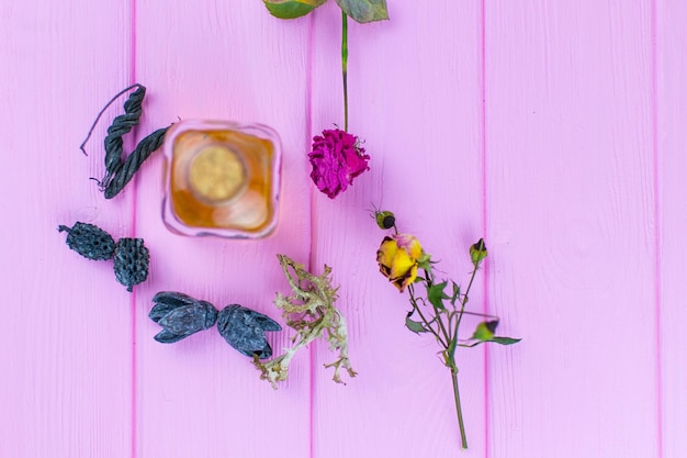 Eine Flasche mit einem gelben Elixier auf einem rosa Holzhintergrund