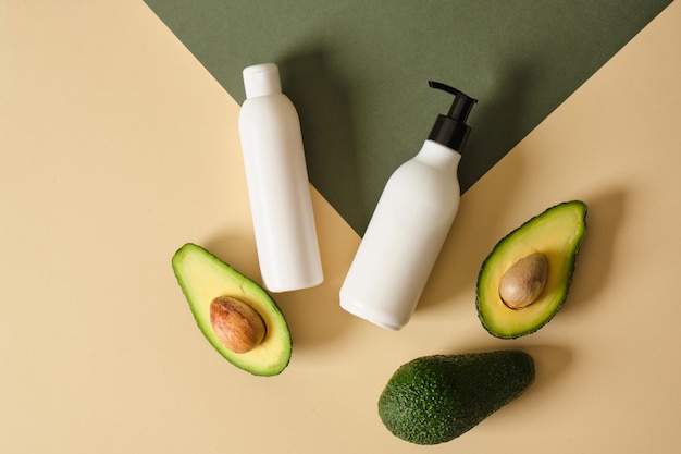 Eine Flasche Sahne mit Avocadoscheiben auf grünem Hintergrund Naturkosmetik-Konzept