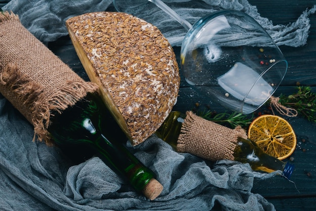 Eine Flasche Wein, Käse und Gewürze italienische Küche auf einer Holzoberfläche Draufsicht Freier Platz für Ihren Text
