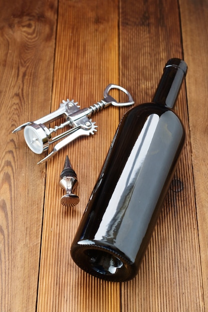 Eine Flasche Wein mit Corckscrew, rustikal aus Holz. Flaches Laienweingetränk mit copyspace.