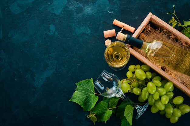 Eine Flasche Wein mit Gläsern und Trauben Blätter von Trauben Draufsicht auf schwarzem Steinhintergrund Freier Platz für Text