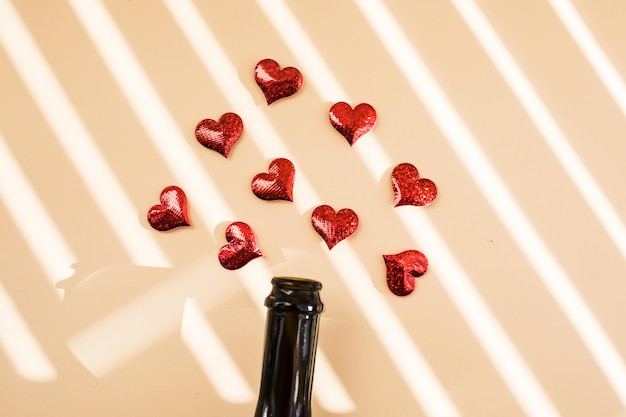 Eine Flasche Wein und rote Herzen über dem Morgenschatten überlagern das Anfangskonzept des Valentinstags