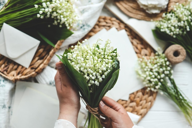 Eine Floristin hält einen Strauß Maiglöckchen in ihren Händen