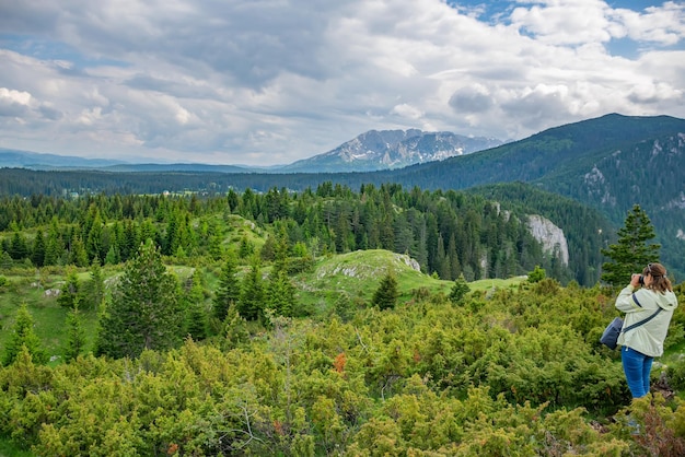 Eine Fotografin macht einen Schnappschuss einer herrlichen Berglandschaft