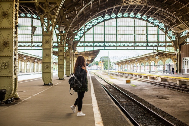 Eine Frau an einem Retro-Bahnhof