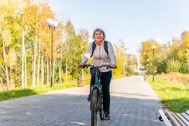 Eine Frau auf einem Fahrrad fährt auf der Straße im Stadtpark