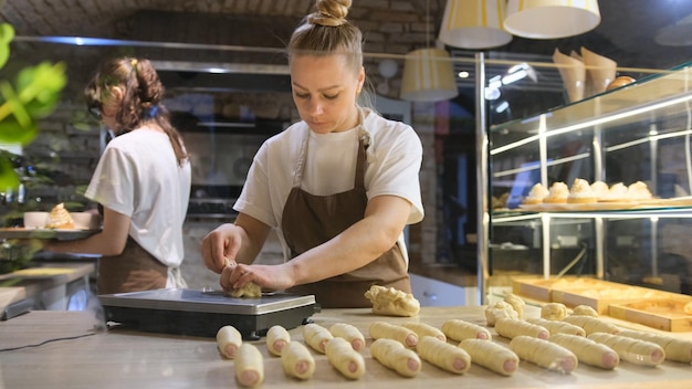 Eine Frau backt Brot in einer Bäckerei.