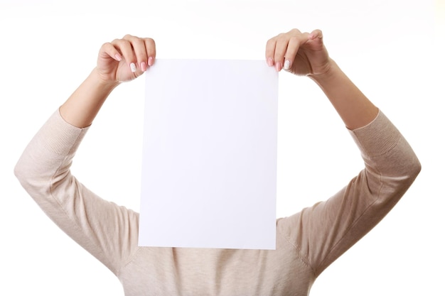 Eine Frau bedeckt ihr Gesicht mit einem leeren Blatt Papier, das auf Weiß isoliert ist