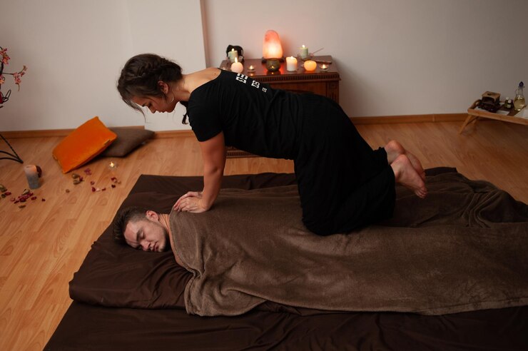 Foto eine frau beim yoga auf einem bett mit einem mann auf dem rücken.