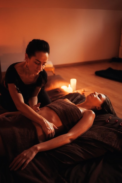 Eine Frau bekommt eine Massage mit einem Feuer im Hintergrund.