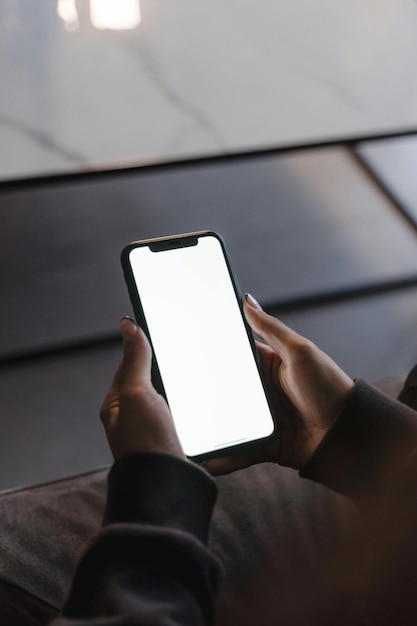eine Frau benutzt ein Telefon mit einem leeren Bildschirm