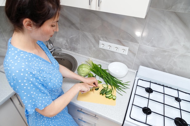 Eine Frau bereitet in der Küche einen Salat zu