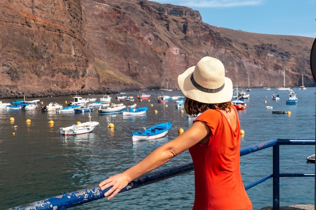 Eine Frau blickt vom Fischerhafen des Dorfes Valle Gran Rey auf den Kanarischen Inseln La Gomera auf den Strand